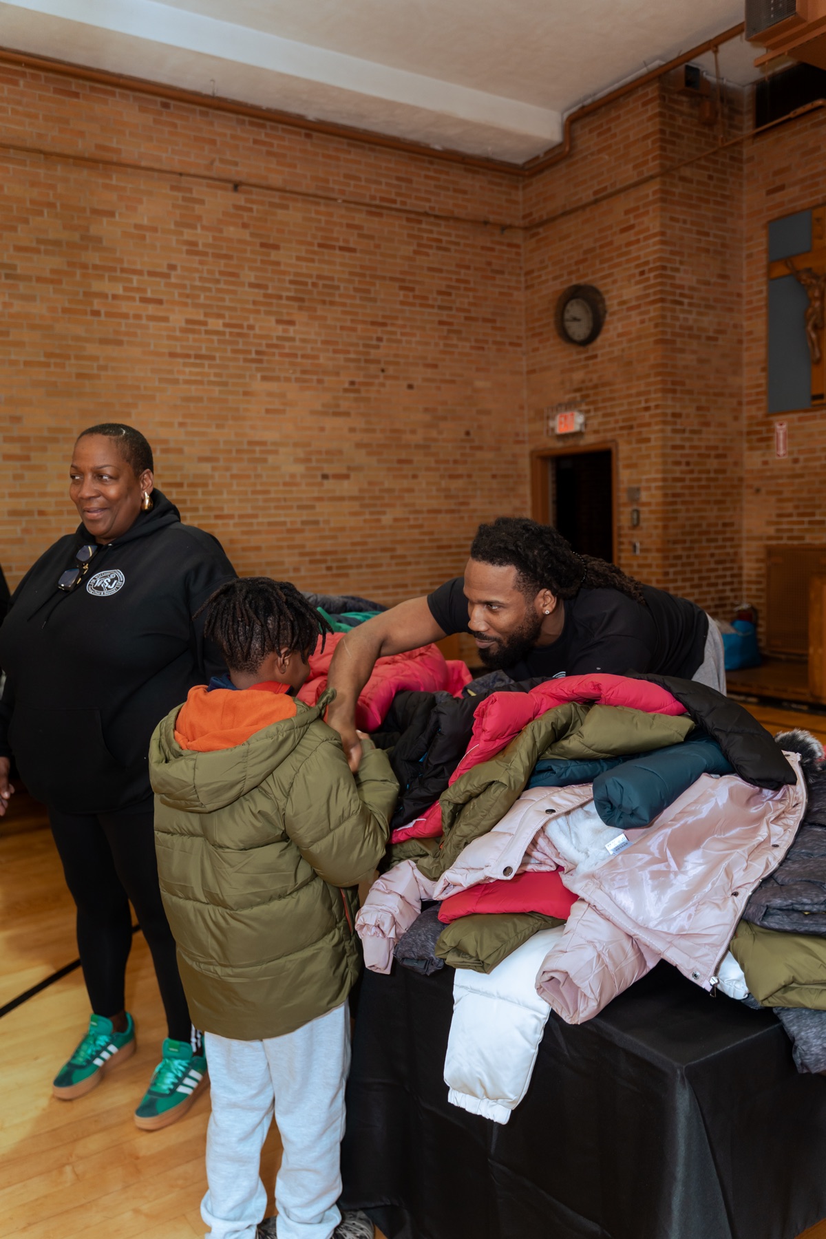 WSJ Crossover volunteers helping a young person select a winter coat during an annual giveback
